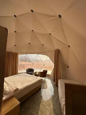 a bedroom with a tent with a bed and a chair at Sana Rum Luxury Camp in Wadi Rum