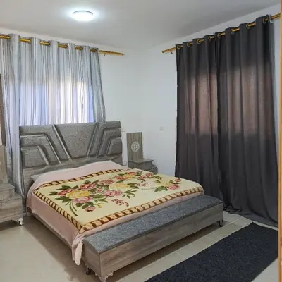 a bedroom with a large bed with a blanket on it at ابو عبدالله للشقق الفندقيه in Ajloun