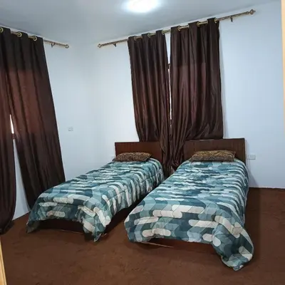 two beds sitting in a room with curtains at ابو عبدالله للشقق الفندقيه in Ajloun