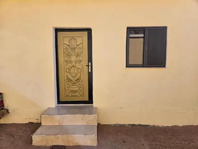 a gold door on a building with a window at Rum Adventures Hostel in Wadi Rum