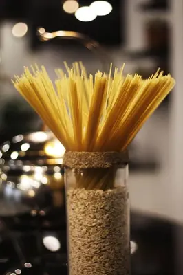 a vase filled with uncooked spaghetti noodles at Amman West Luxury Hotel By Azar in Amman
