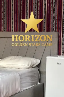 a houston golden stars camp sign on a bed at Horizon Star Golden Camp in Wadi Rum
