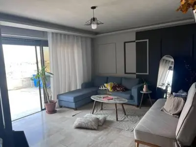 a living room with a blue couch and a table at Doctor roof in Amman