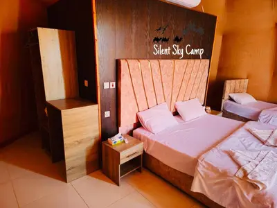 a bedroom with two beds and a sign that reads shut ski camp at SILENT SKY lUXURY CAMP in Wadi Rum