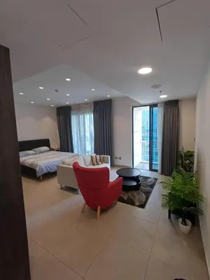 a living room with a bed and a red chair at Studio at Damac Jordan in Amman