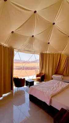 a bedroom with a bed and a large tent at RUM AlLIRA lUXURY CAMP in Wadi Rum