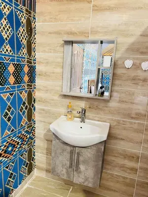 a bathroom with a sink and a mirror at RUM AlLIRA lUXURY CAMP in Wadi Rum