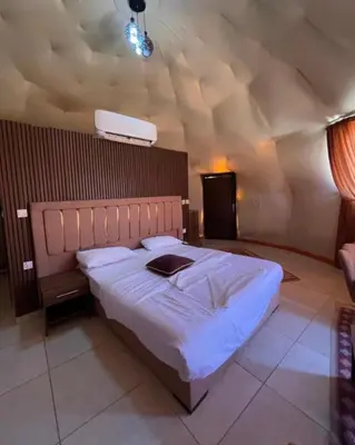 a bedroom with a large bed in a room with a ceiling at RUM AlLIRA lUXURY CAMP in Wadi Rum