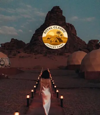 a woman walking down a path in the desert with candles at RUM ROYAL CLASSIC lUXURY CAMP in Disah
