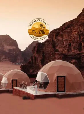 a person standing in front of three tents in the desert at RUM ROYAL CLASSIC lUXURY CAMP in Disah