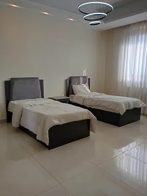 two beds sitting next to each other in a bedroom at شقه مفروشه in Amman