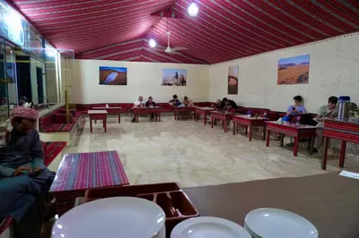 a group of people sitting at tables in a room at moon and sky camp in Wadi Rum