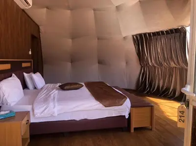 a bedroom with a large bed with white sheets at moon and sky camp in Wadi Rum