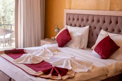 a large bed with red and white sheets and pillows at moon and sky camp in Wadi Rum
