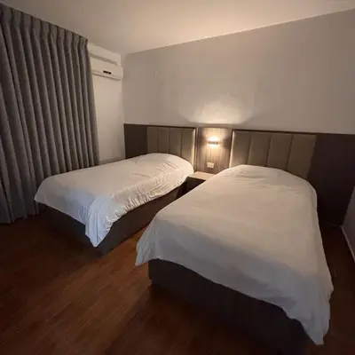 a hotel room with two beds and a window at Al-Farouq Suites in Amman