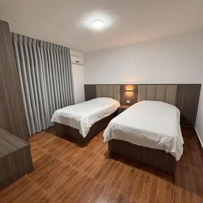 a hotel room with two beds and a window at Al-Farouq Suites in Amman