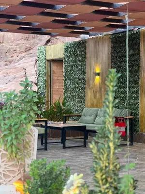 a patio with a couch and a table and plants at Al-Najm Coastal Camp Rum in Wadi Rum