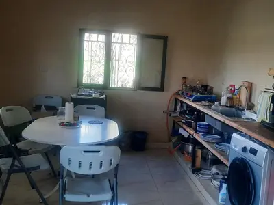 a kitchen with a table and chairs and a window at استراحة الباشا albash farm stay in Al Karāmah