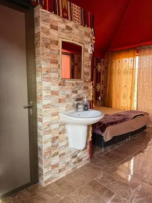 a bathroom with a sink and a bed at Ayloulcamp in Disah