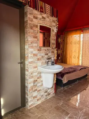 a bathroom with a sink and a bed at Ayloulcamp in Disah