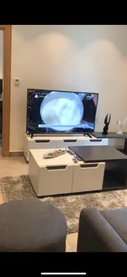 a flat screen tv sitting on a table in a living room at DAMAC Tower Amman boulevard برج داماك - عمان البوليفارد العبدلي in Amman