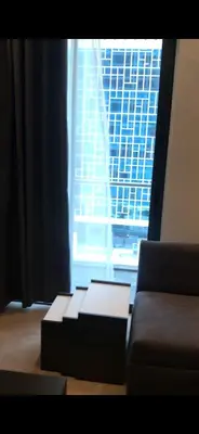 a living room with a couch and a large window at DAMAC Tower Amman boulevard برج داماك - عمان البوليفارد العبدلي in Amman