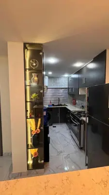 a kitchen with black cabinets and a refrigerator at شقة مفروشة apartment amman alnuzzha in Amman