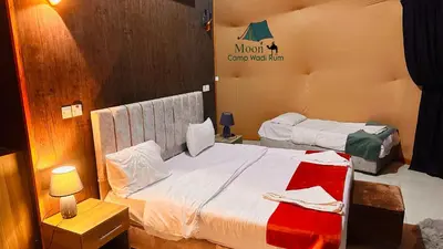 a bedroom with two beds and a sign on the wall at Moon Camp Wadi Rum in Wadi Rum