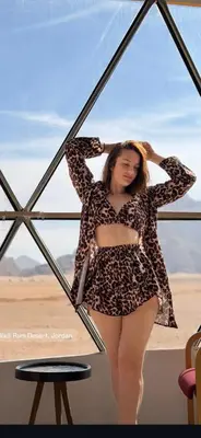 a woman is posing in a leopard print dress at Moon Camp Wadi Rum in Wadi Rum