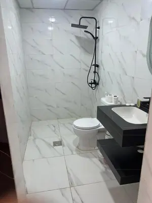 a white bathroom with a toilet and a sink at Moon Camp Wadi Rum in Wadi Rum
