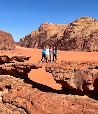 a group of people standing on a bridge in the desert at Wadi Rum Bedouin Life in Wadi Rum