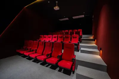 an auditorium with red chairs in a theatre at كمباوند المطار شقه مفروشة in Amman