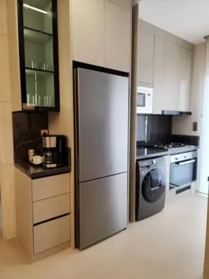 a kitchen with a stainless steel refrigerator and a stove at كمباوند المطار شقه مفروشة in Amman