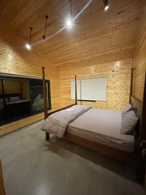 a bedroom with a bed in a wooden room at Cherry farm in Ajloun