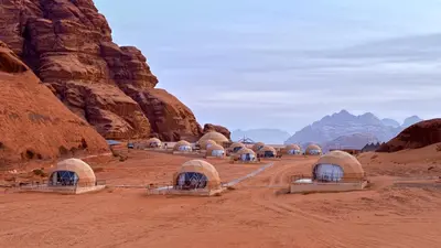 a group of domes in a desert with mountains at SARH lUXURY CAMP in Wadi Rum