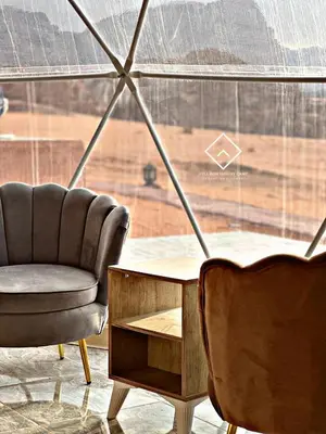 a room with a chair and a table and a window at ALYA RUM LUXURY Camp in Wadi Rum