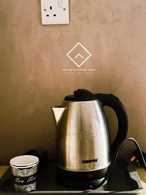 a tea kettle sitting on a table next to a cup at ALYA RUM LUXURY Camp in Wadi Rum
