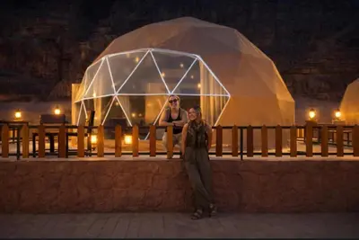 a woman standing in front of a glass dome at ROYAL LANCASTER lUXURY CAMP in Wadi Rum