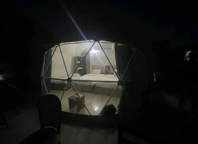 a small room with a bed in a glass dome at mountains wadi rum in Disah