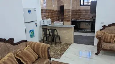 a living room with a couch and a kitchen at فيلا سالم عبدالرحمن الأشــــــقــــر ابو حمزه Villa Salem Alashqar in Maḩaţţat al Jīzah