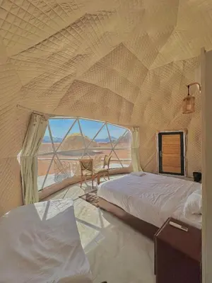 a bedroom with two beds and a view of the desert at Moon Red Bubbles Camp in Wadi Rum