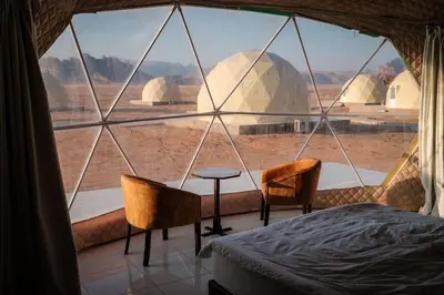 a bedroom with a view of a desert from a window at Moon Red Bubbles Camp in Wadi Rum
