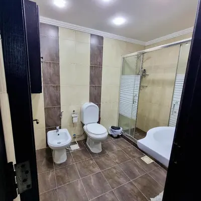 a bathroom with a toilet and a sink and a tub at Deir Ghbar Suite in Amman