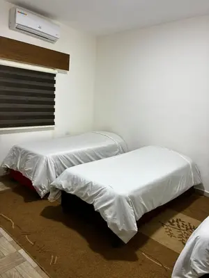 a room with two beds with white sheets at New Roman's kingdom in Madaba