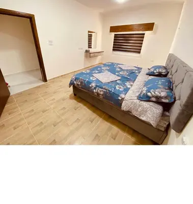 a bedroom with a bed with blue sheets on it at New Roman's kingdom in Madaba