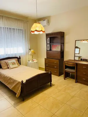 a bedroom with a bed and a desk and a mirror at شقة مفروشة الدوار الخامس in Amman