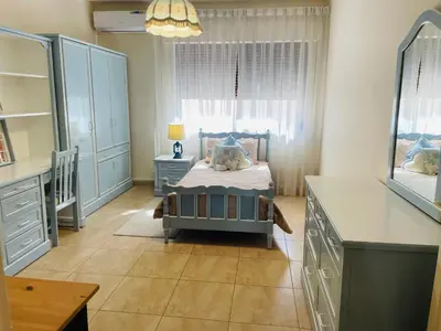 a bedroom with a bed and a dresser and a window at شقة مفروشة الدوار الخامس in Amman