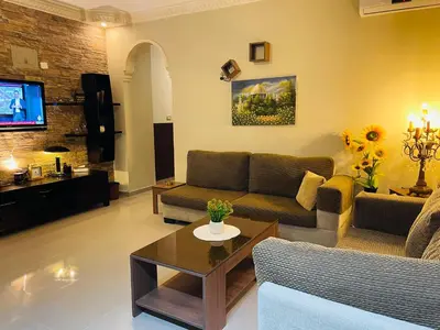 a living room with a couch and a table at شقة مفروشة بالجبيهة in Amman