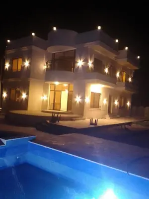 a large house at night with a swimming pool at شاليه ريست سي Rest Sea Chalet