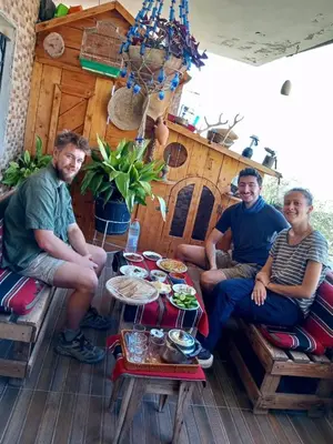 a group of three men sitting around a table at اربد ام قيس طريق درب الاردن in Um Qeis